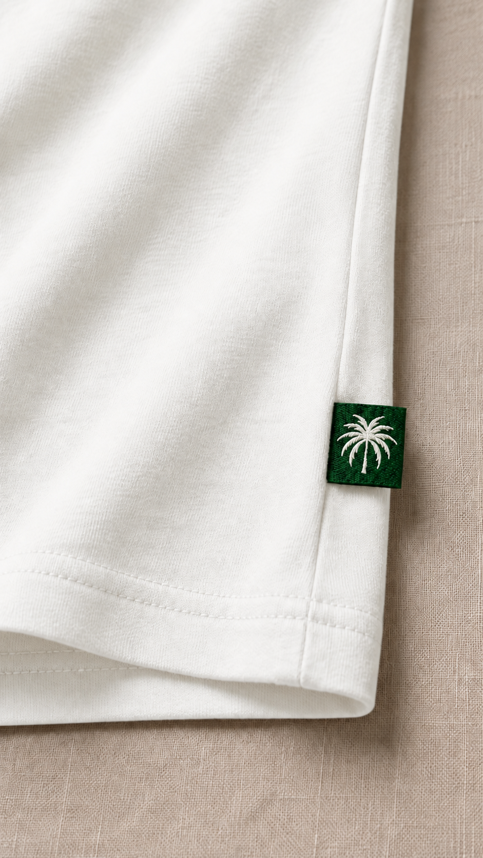 Dobladillo de la camiseta blanco lino con la etiqueta de la palma