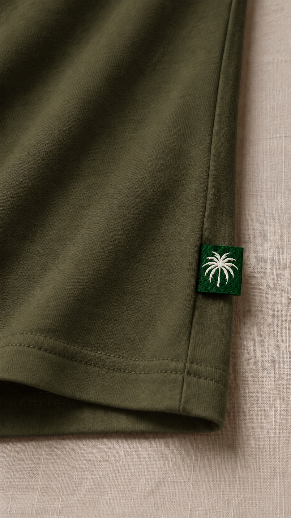 Dobladillo de la camiseta verde oliva con la etiqueta de la palma